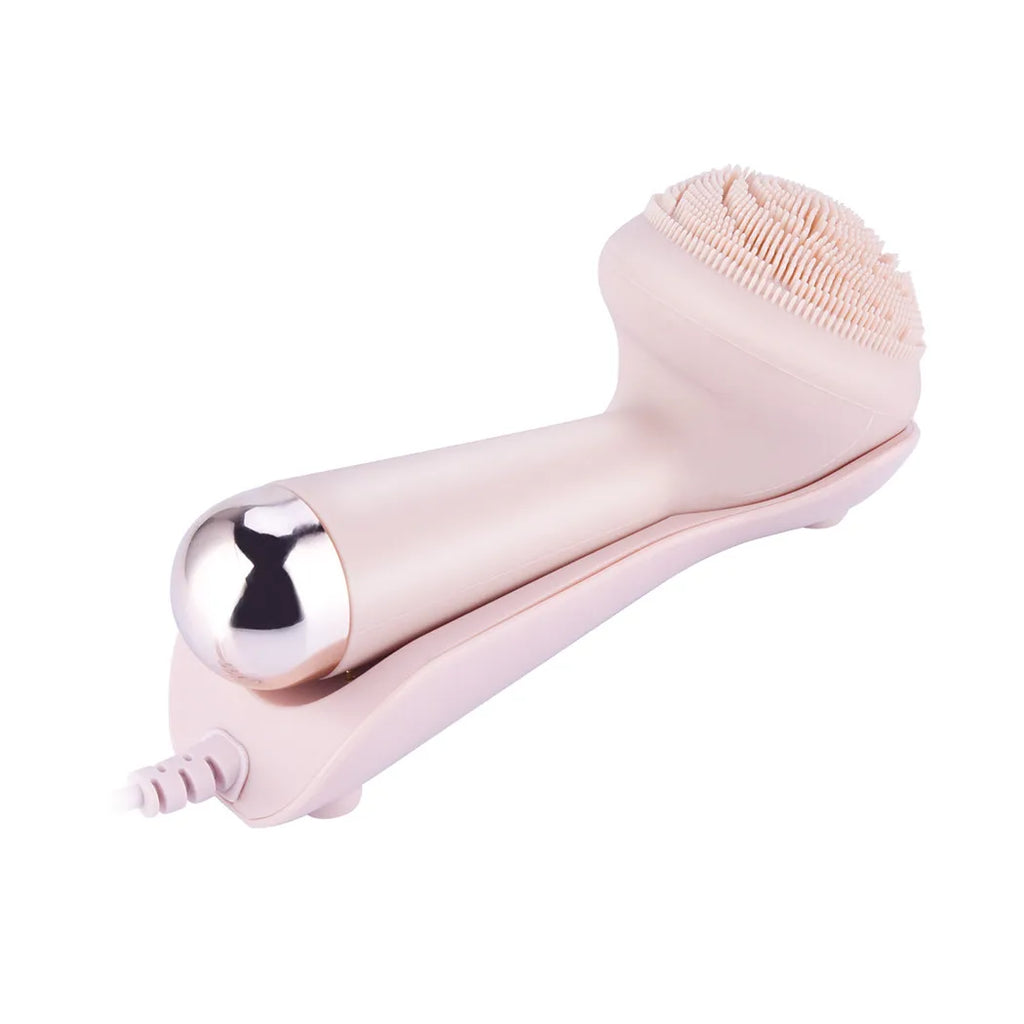 Side angle view of pink silicone facial cleansing brush showing soft bristle head and gold roller massage ball tip
