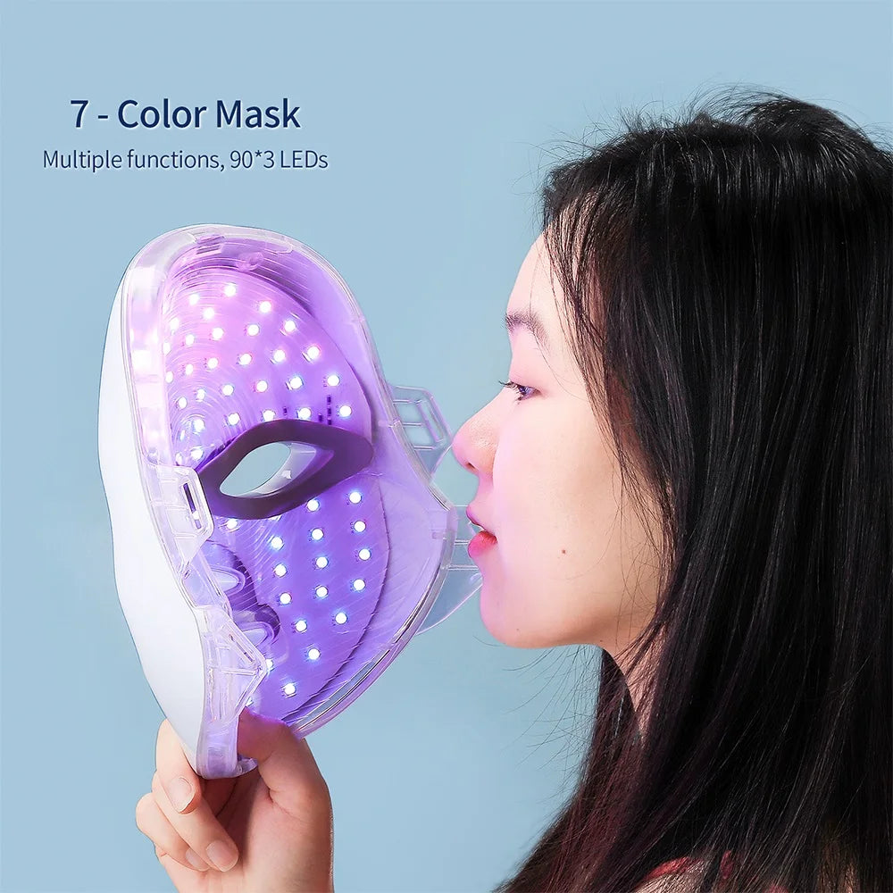 Woman holding 7-Colours LED Light Therapy Face Mask showing purple light mode with 90×3 LEDs activated