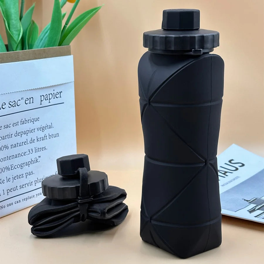 Foldable silicone water bottle in Matte Black shown upright and folded flat, with carrying strap – 600ml portable reusable bottle