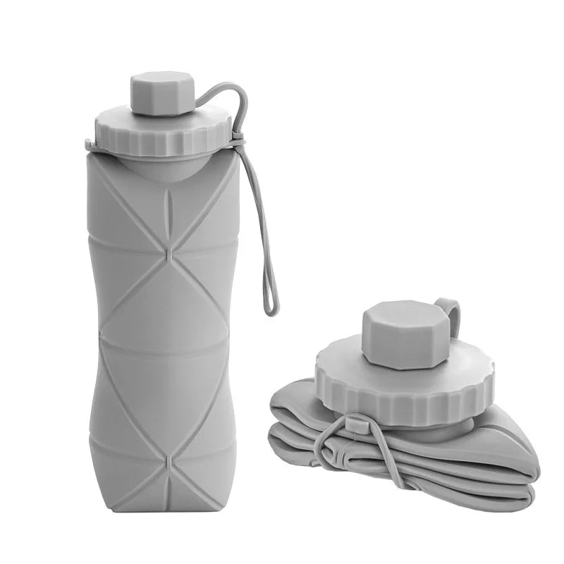 Foldable silicone water bottle in Ash Grey shown upright and folded flat, with carrying strap – 600ml portable reusable bottle